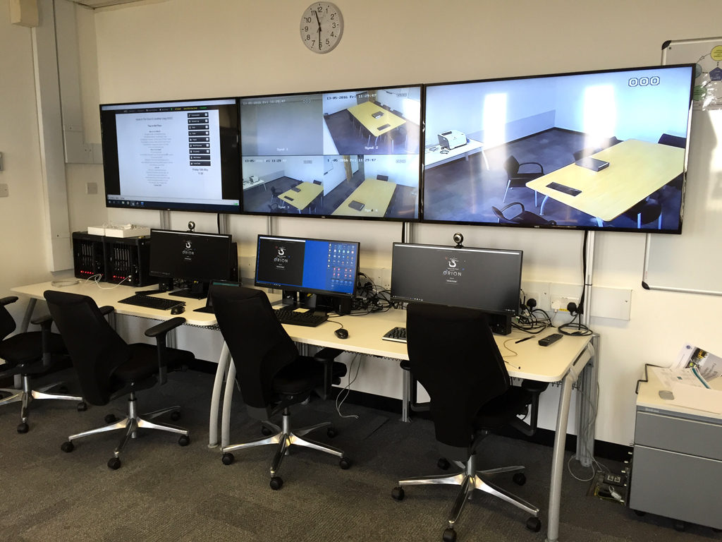 Hydra control room with workstations and screens showing adjoining rooms