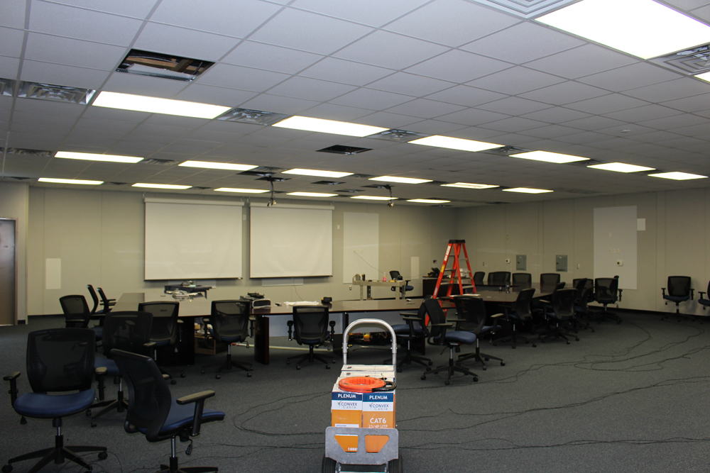 Large training room under construction with projection screens and workstations
